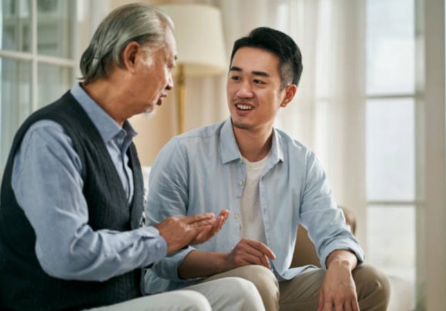 An older man and a younger man talking together